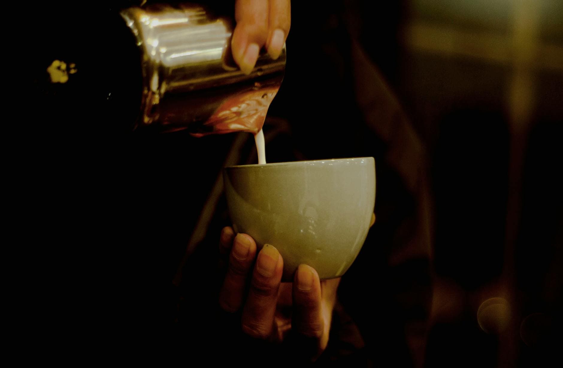 Barista pouring latte art in a cozy cafe
